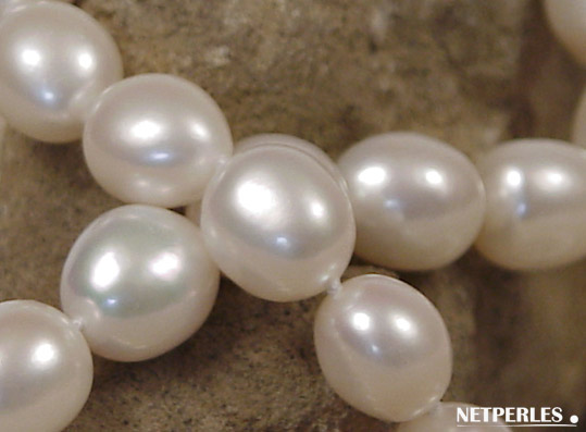 Gros plan de perles baroques d'eau douce blanches, soyeuses, douces, et fortes ces perles font des colliers merveilleux